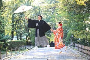 金沢市の観光名所「兼六園」で番傘を使用しながら前撮りをする新郎新婦様
