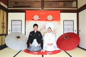 花嫁のれん前で正座をする新郎新婦様