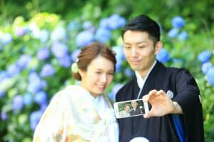 スマホで自撮りをしながら撮影する新郎新婦様