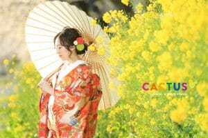 番傘を持って菜の花の中で和装の前撮りをする新郎新婦様