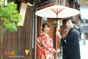 金沢市の観光名所は東茶屋街で番傘を持って振り返る新郎新婦様。