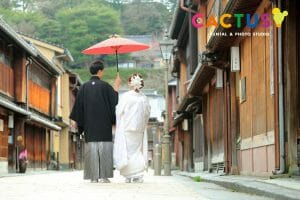 金沢市内の観光名所、東茶屋街のメイン通りで番傘を持って歩く新郎新婦様
